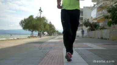 慢动作斯坦尼康拍摄的一个人与智能手机<strong>慢跑</strong>沿海滨度假小镇积极的生活方式和运动